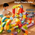 Child playing with a colorful Magic Track Cube toy set on a wooden floor.